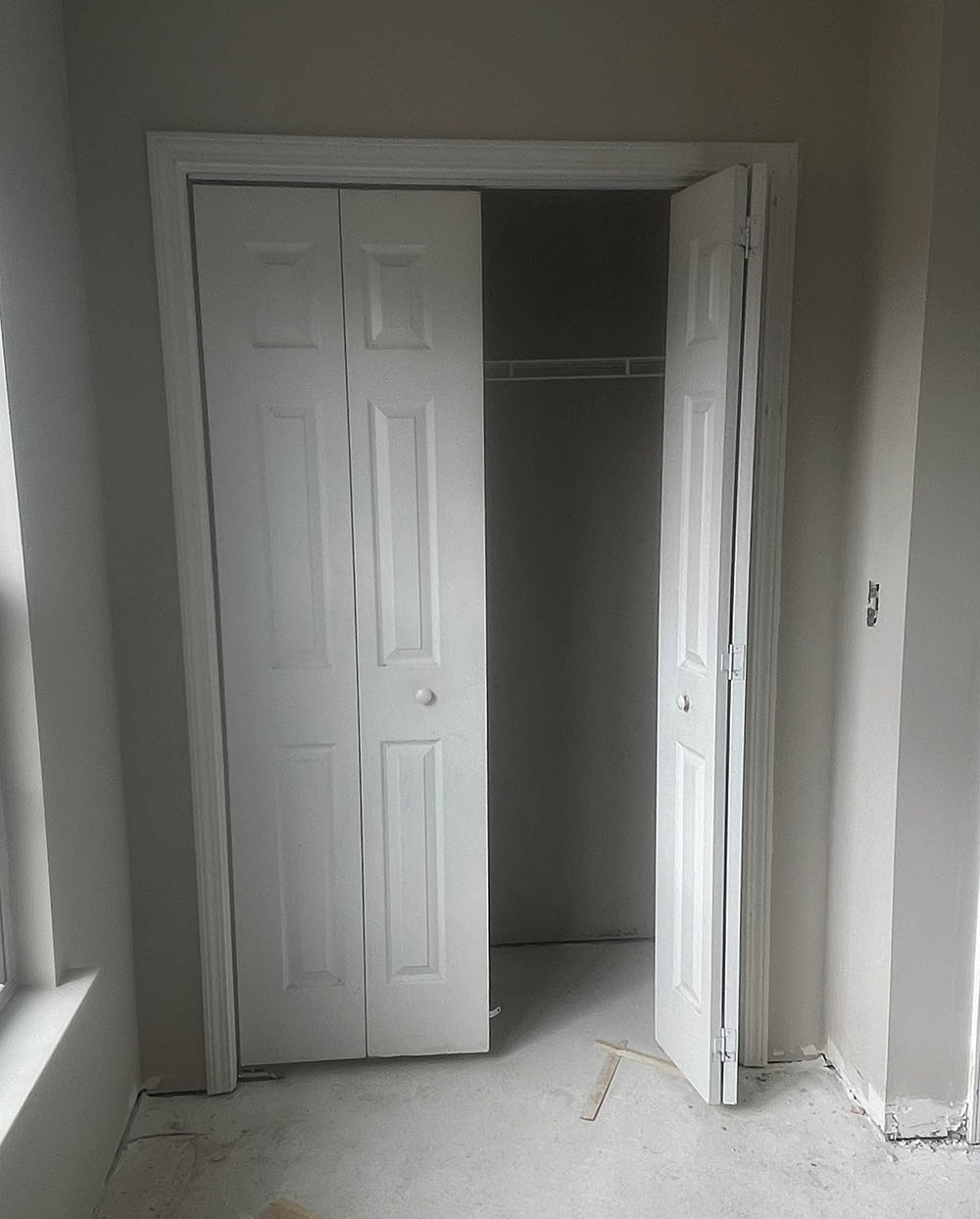 Interior bi-fold closet door and trim installation with one door open